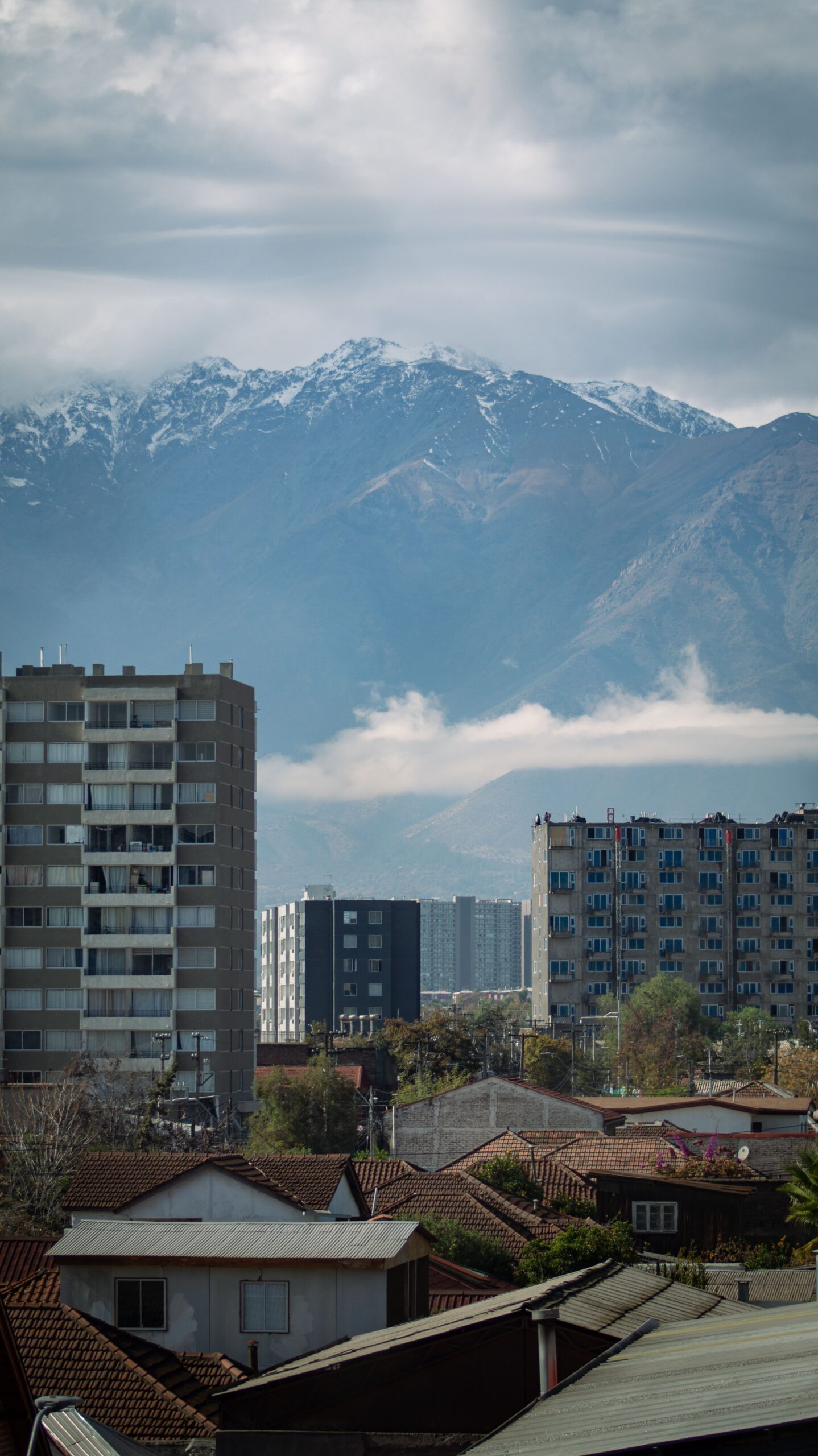 Cityscape with snow-capped mountains in the background, clear day view.
